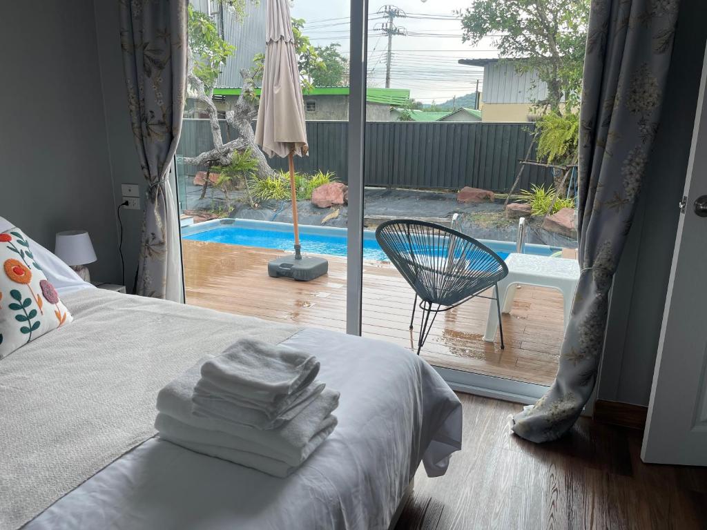 une chambre avec un lit et une vue sur une piscine dans l'établissement Home stay Ev Coffeehouse, à Ban Map Khao Wan