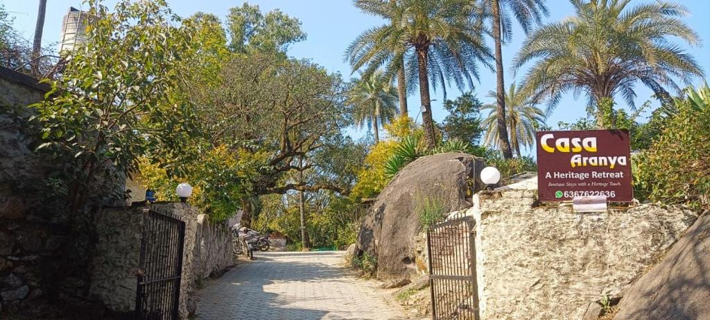 Casa Aranya - A Heritage Retreat في مونت ابو: علامة على جانب الطريق مع أشجار النخيل