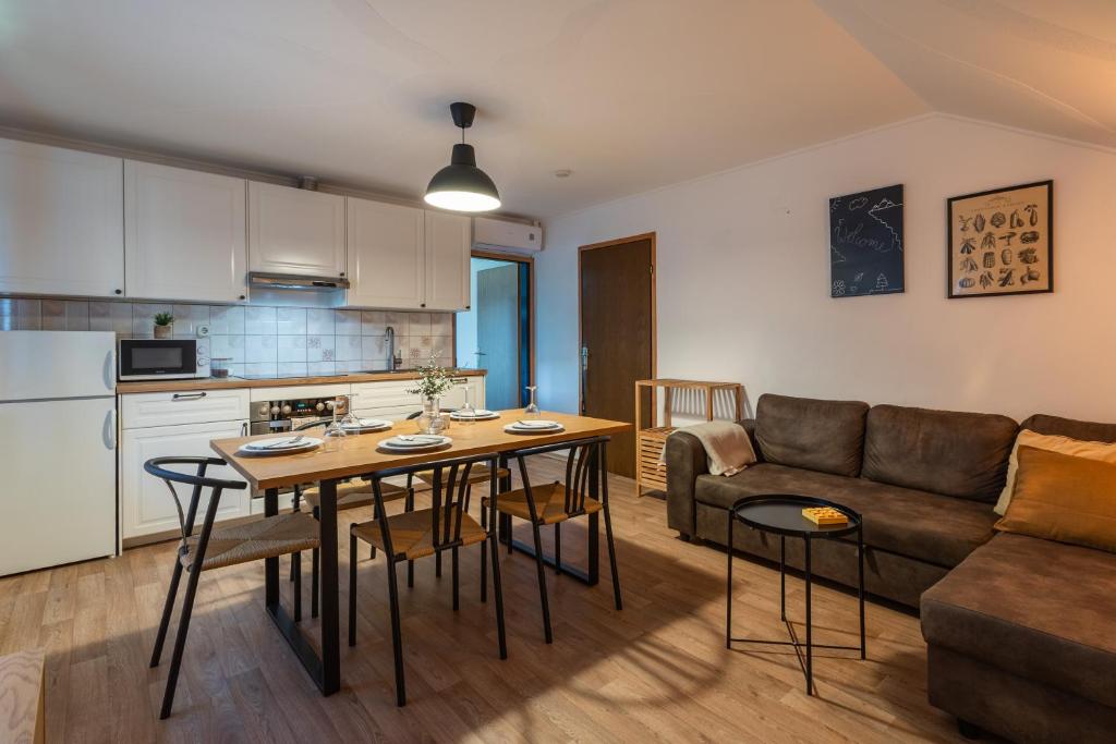 Una cocina y una sala de estar con una mesa y un sofá. en Apartments Orel, en Mozirje