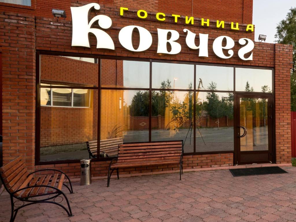 a store with two benches in front of a building at Hotel Kovcheg in Surgut