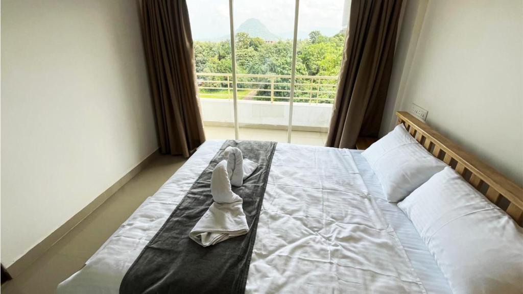 un par de zapatos sentados en una cama con una ventana en Dodamarg Heights, en Dodamarg