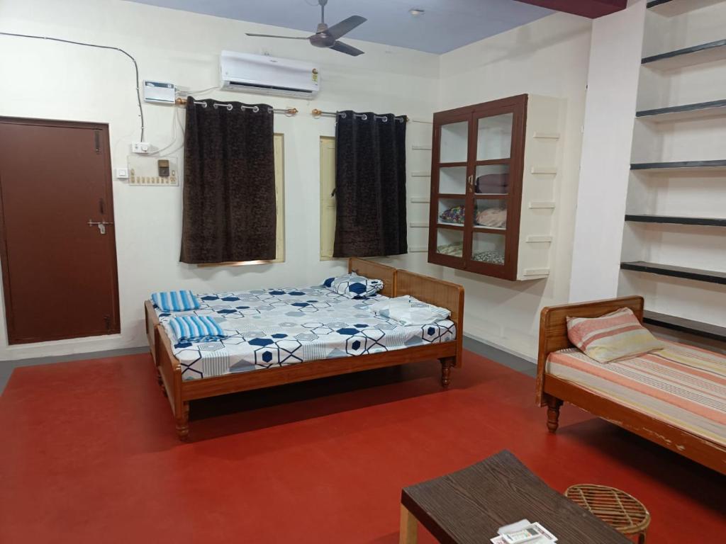 una camera con un letto e un divano. di Adb's Kuzhlam Rooms a Tiruchchirāppalli
