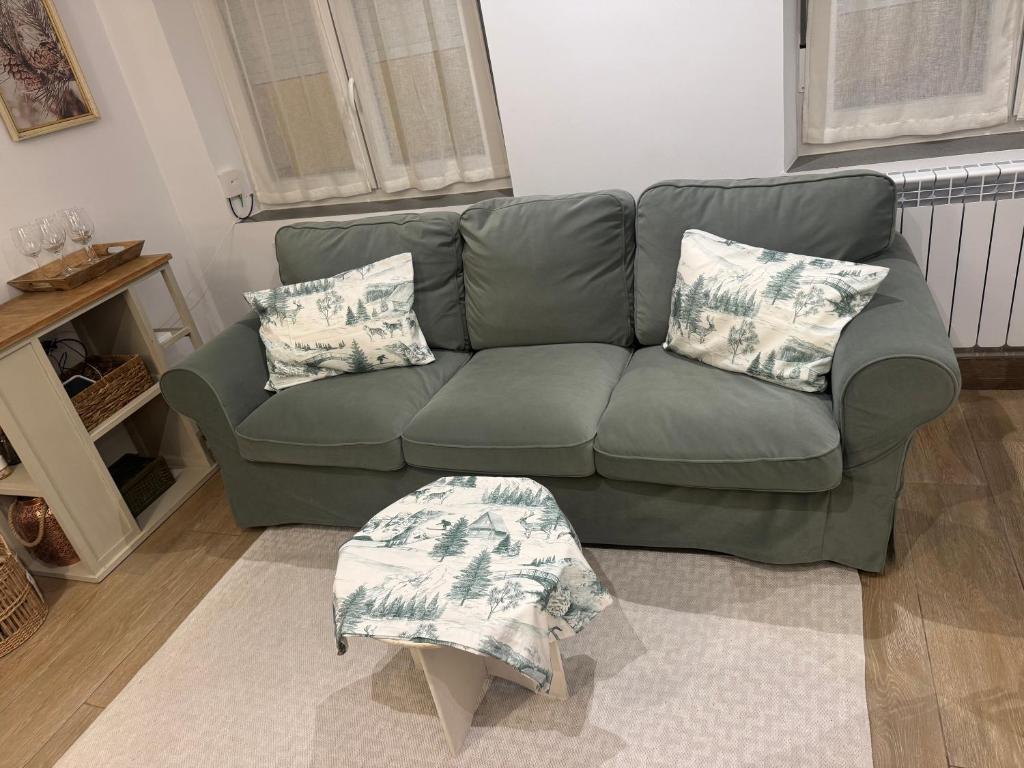 a green couch with pillows in a living room at Apartamento La Sabina in Reinosa