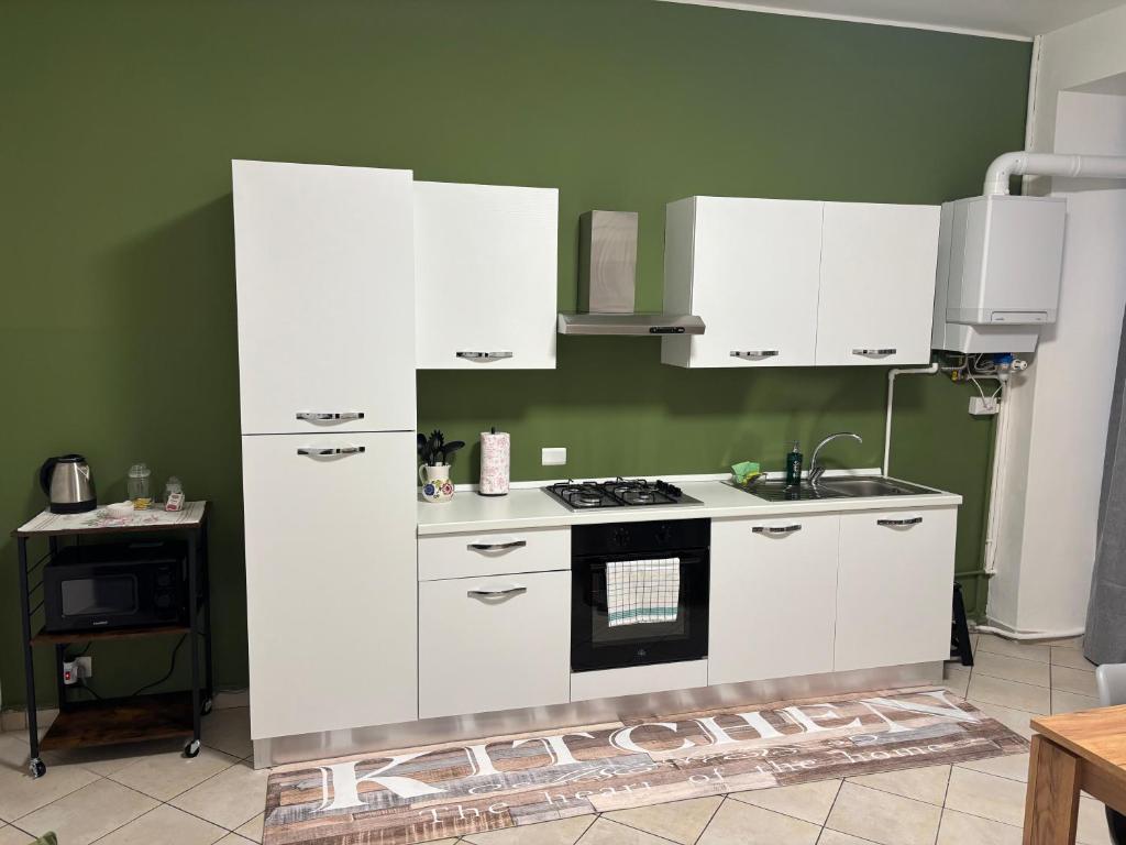 a kitchen with white cabinets and a stove at Casa Malvina in Intra