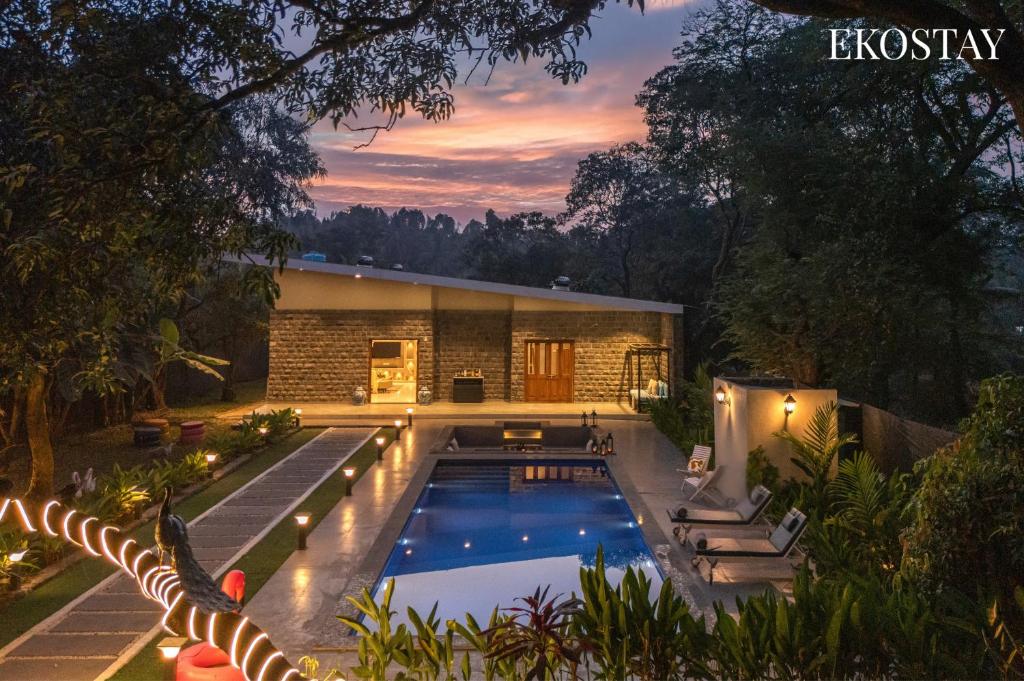 a swimming pool in the backyard of a house at EKOSTAY - The Clay House in Alibaug