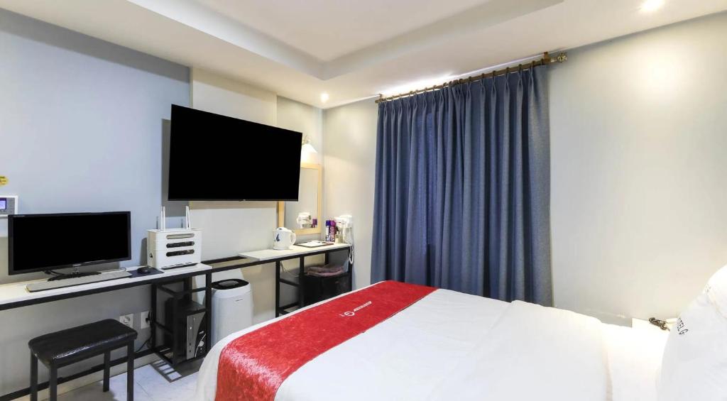 a hotel room with a bed and a desk with a computer at Jukdo market G1mini in Pohang
