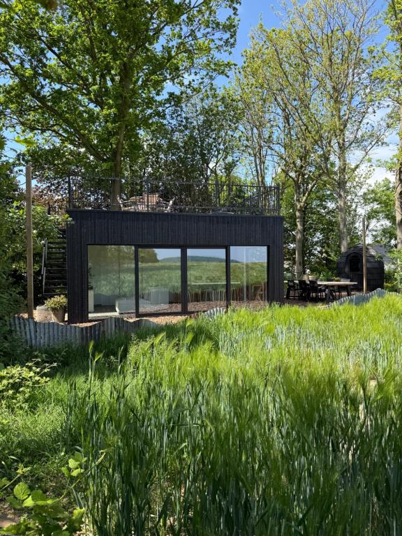 een zwart huis in een grasveld bij The Nest 81 in Heuvelland
