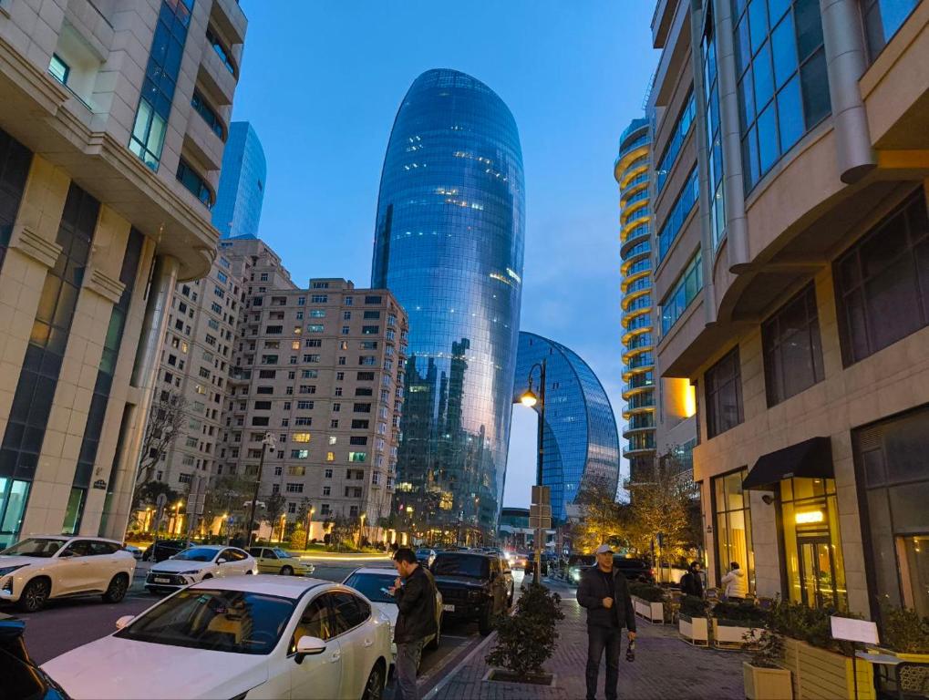 a car parked on a city street with tall buildings at DeLux Hotel Baku in Baku