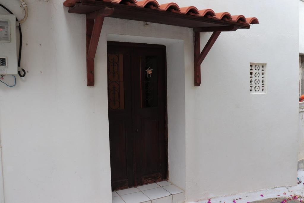 a door of a white building with a red roof at Bougainvillea in Andros