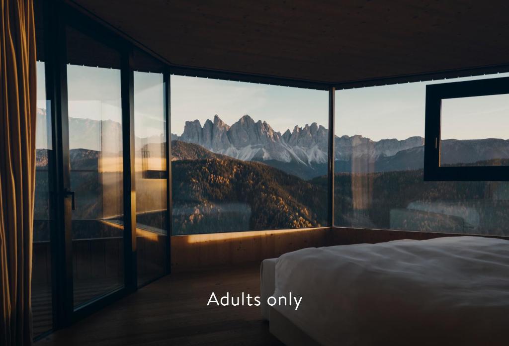 1 dormitorio con cama y vistas a las montañas en Forestis Dolomites, en Bresanona