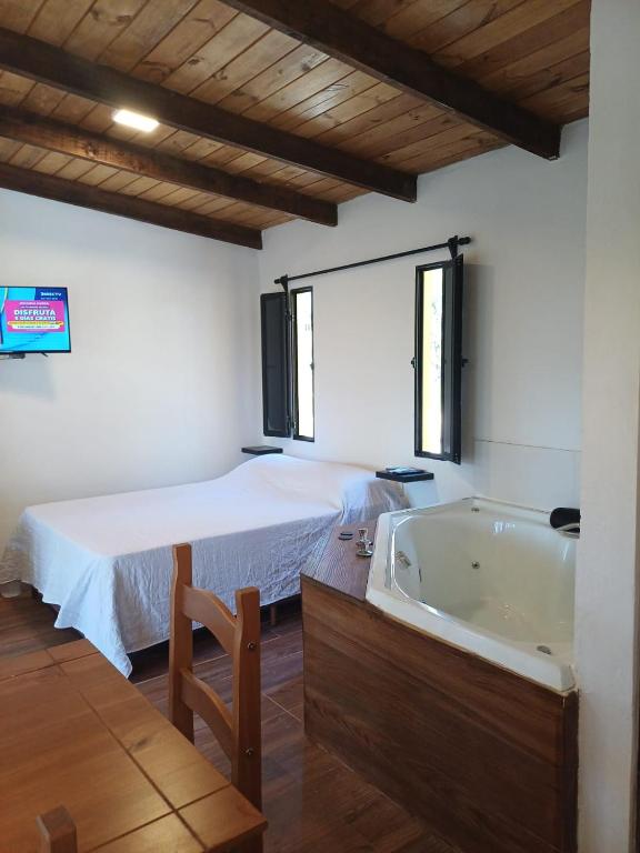 a bedroom with a bed and a bath tub at AIRES DEL BOSQUE Con JACUZZI in Punta Del Diablo
