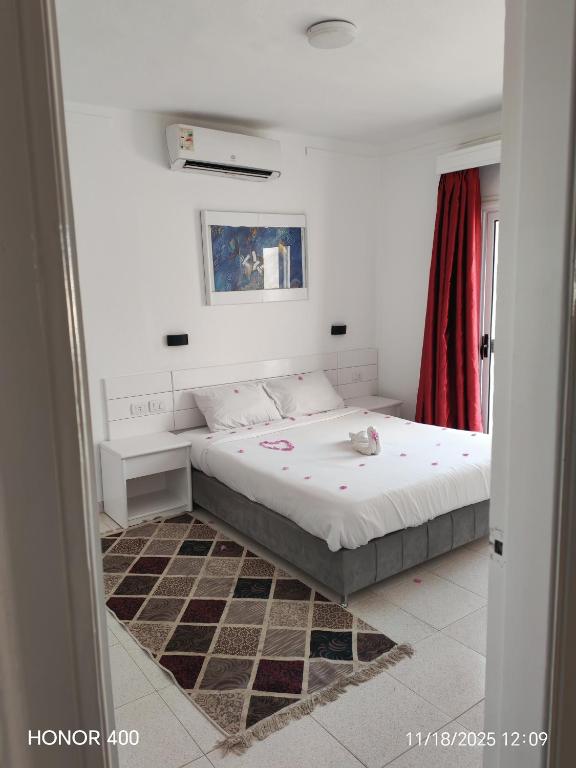 a bedroom with a bed and a red curtain at Elixir Two Bed Rooms in Hurghada