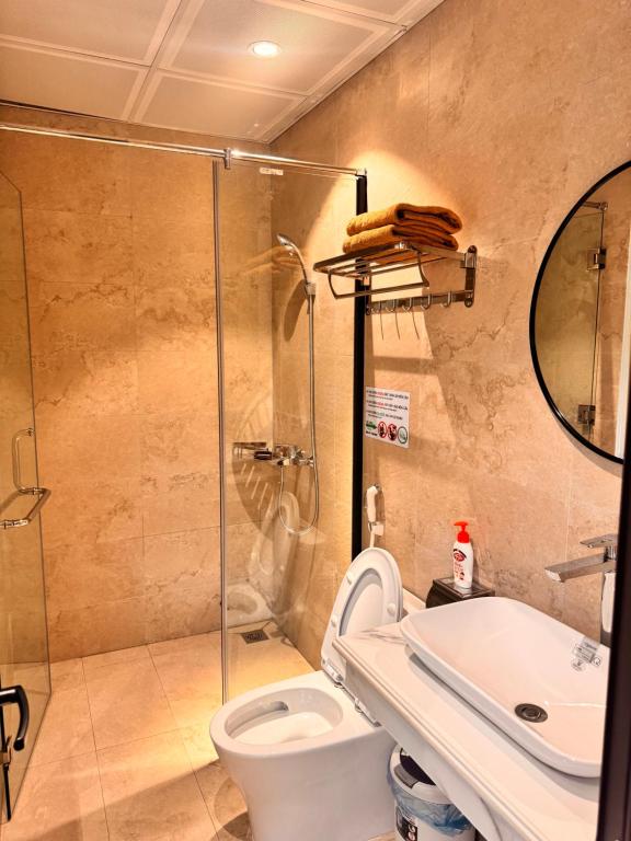 een badkamer met een douche, een toilet en een wastafel bij Cozy Hostel and Tours in Ha Giang