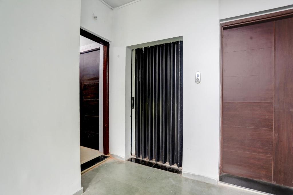 a hallway with two doors and a window at Hotel O Wardha Road Near Airport in Nagpur