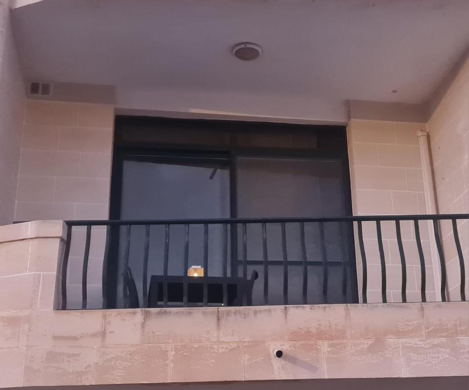 a balcony with a black railing and a window at Charming Seaside Apartment in Mellieħa
