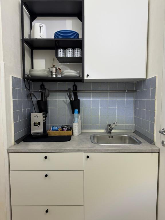 a kitchen with white cabinets and a sink at Cavallerizza home in Naples