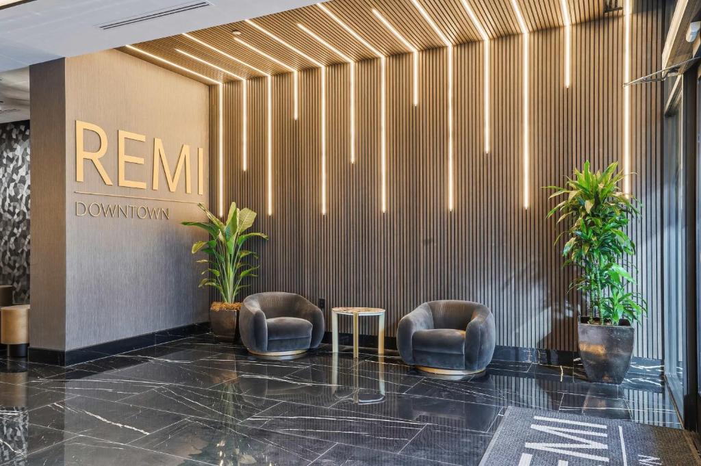 un vestíbulo con 2 sillas y una mesa en un edificio en CozySuites Remi sauna, pool, gym, en Dallas