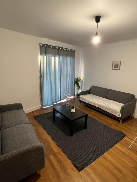 a living room with a couch and a coffee table at Le Toit des Volcans - 8 couchages - Terrasse privée et Wifi in Clermont-Ferrand