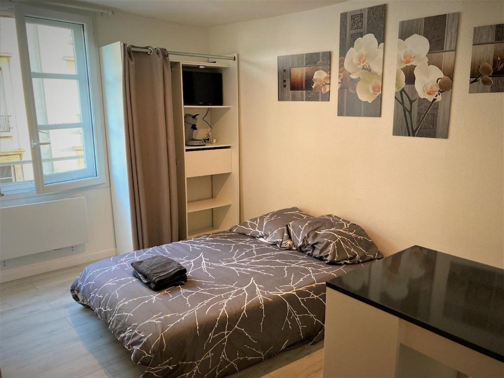 ein Schlafzimmer mit einem Bett mit einer Tasche darauf in der Unterkunft Studio dans l'hypercentre de Limoges in Limoges