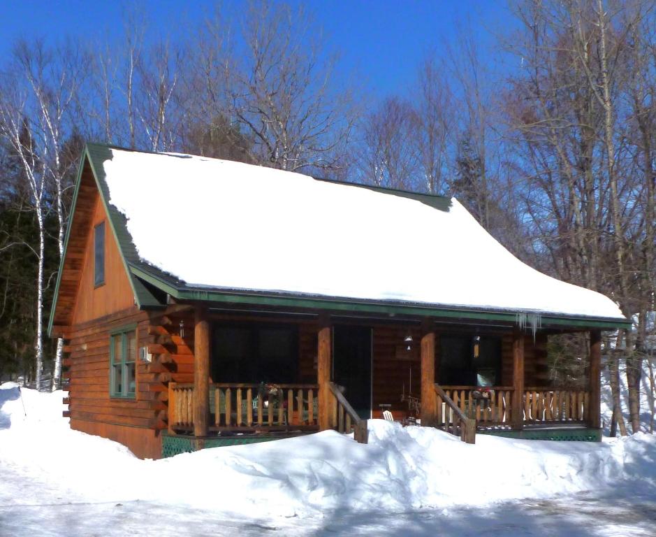 een blokhut met sneeuw op het dak bij Camp Quityerbellyachin in Greenville