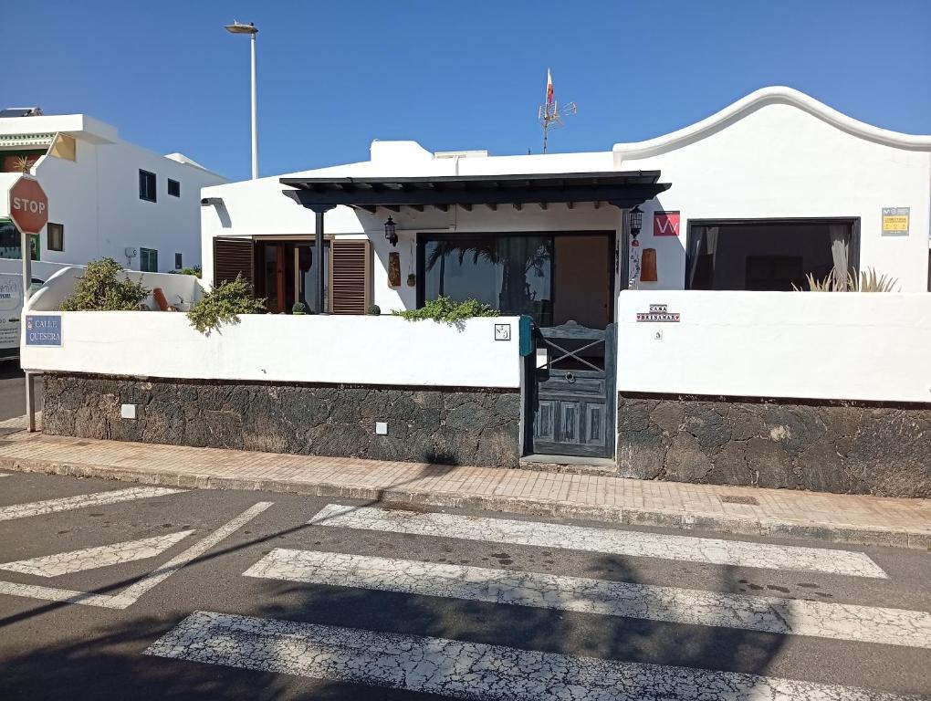 een wit huis met een deur in een straat bij Casa Brisamar in Puerto del Carmen