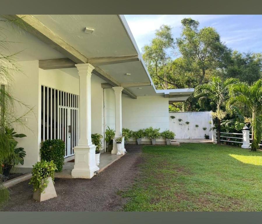 uma casa branca com colunas e um quintal em Villa De'YuLee em Negombo