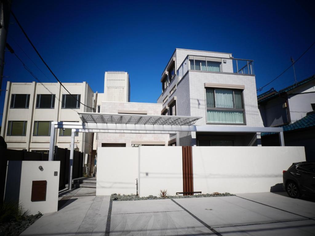 un edificio bianco con una recinzione di fronte di 富津 Fun Base a Futtsu