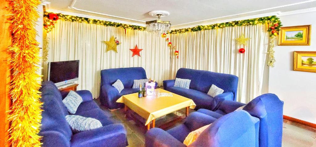 a living room with blue chairs and a table at Villagalicia360 in Bergondo