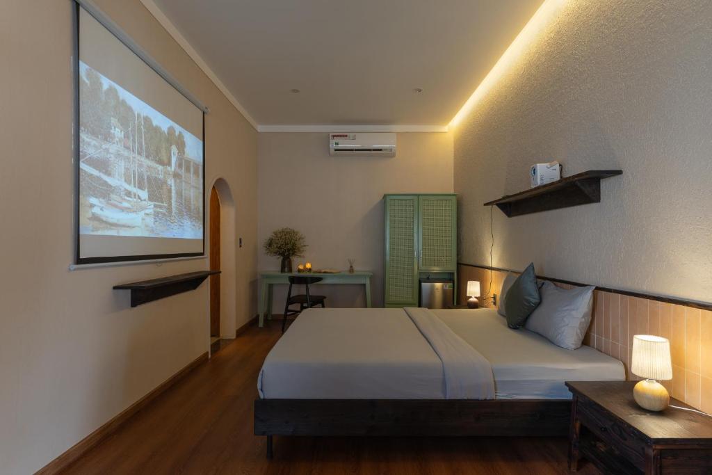 a bedroom with a bed and a projection screen at MOONLIGHT Homestay & Hotel in Pleiku