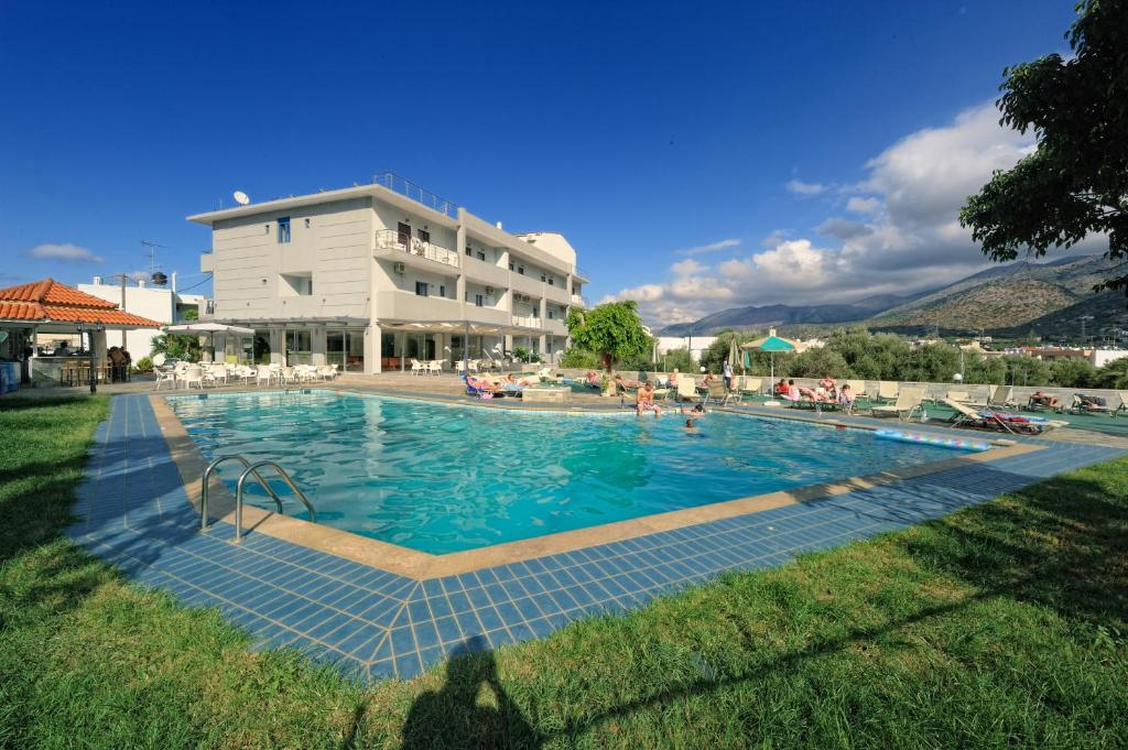 a large swimming pool in front of a building at Hermes Hotel in Malia