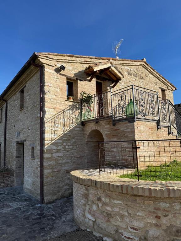 Agriturismo Al Vicinale في جينجا: مبنى حجري قديم مع شرفة عليه