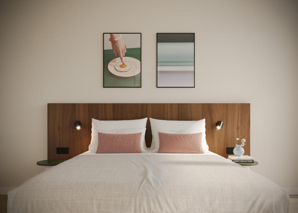 een slaapkamer met een groot wit bed met roze kussens bij Numa Rotterdam Coolsingel in Rotterdam