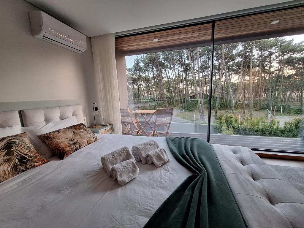 a large bed in a bedroom with a large window at Dunas D'Ofir Village in Fão