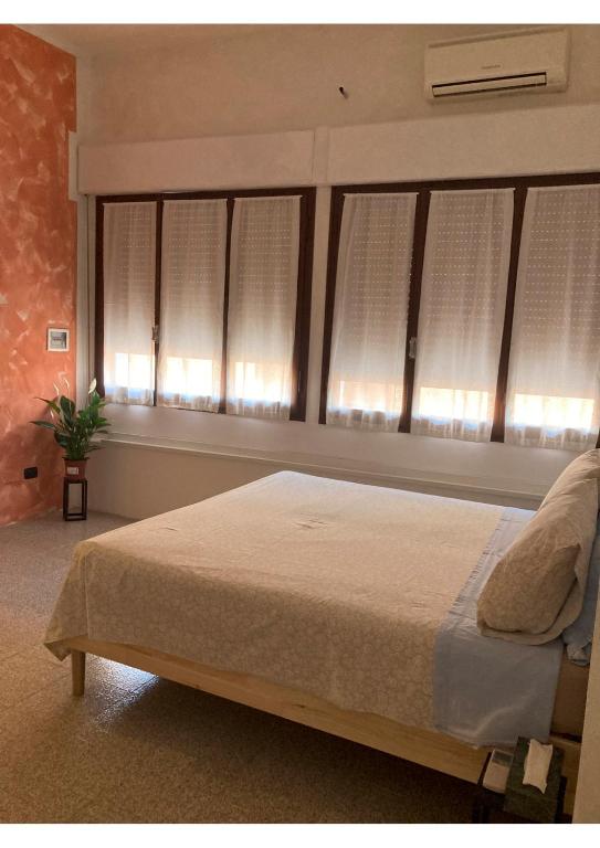 een slaapkamer met een bed en een raam met witte luiken bij Portale dei Soli 2 in Rolo