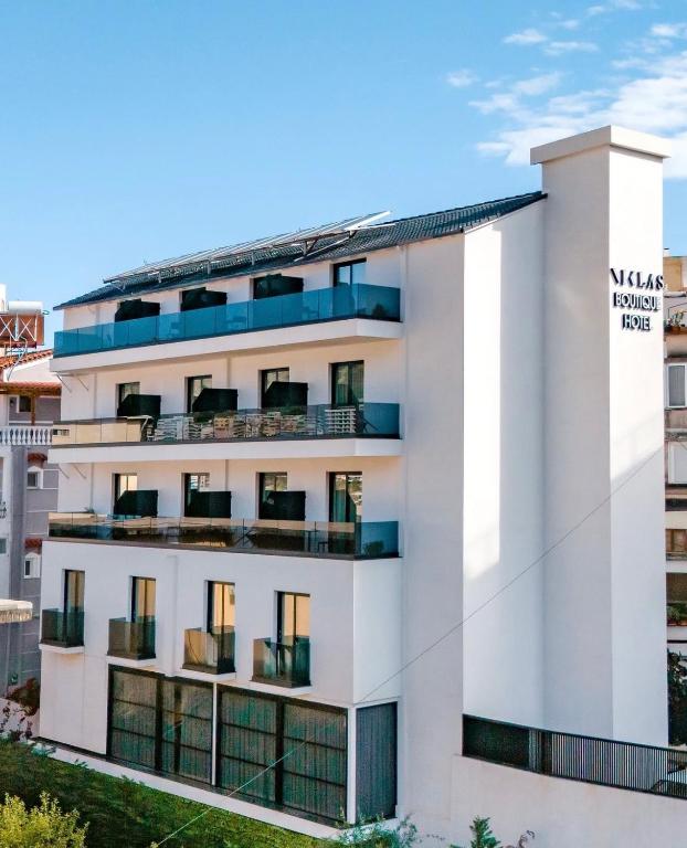a white building with a sign on it at Niklas Boutique Hotel in Sarandë