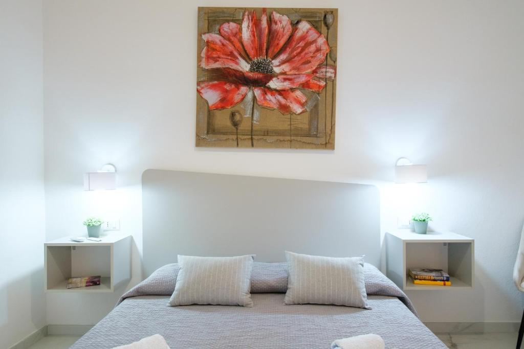 a bedroom with a bed with a flower painting on the wall at Costa Private room in Castelsardo