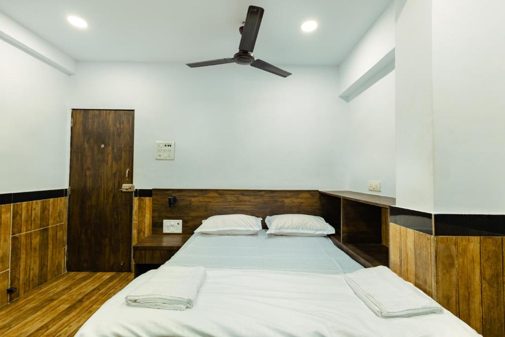 a bedroom with a large bed with a ceiling fan at CozyKey Rooms Bandra in Mumbai