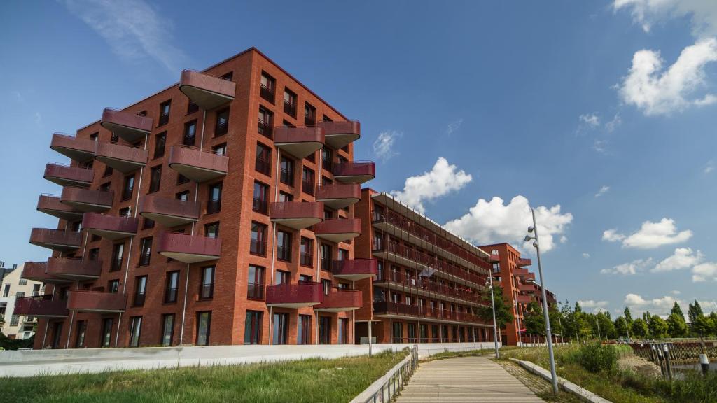 a red building with balconies on the side of it at Maritime Suite an der Geeste in Bremerhaven