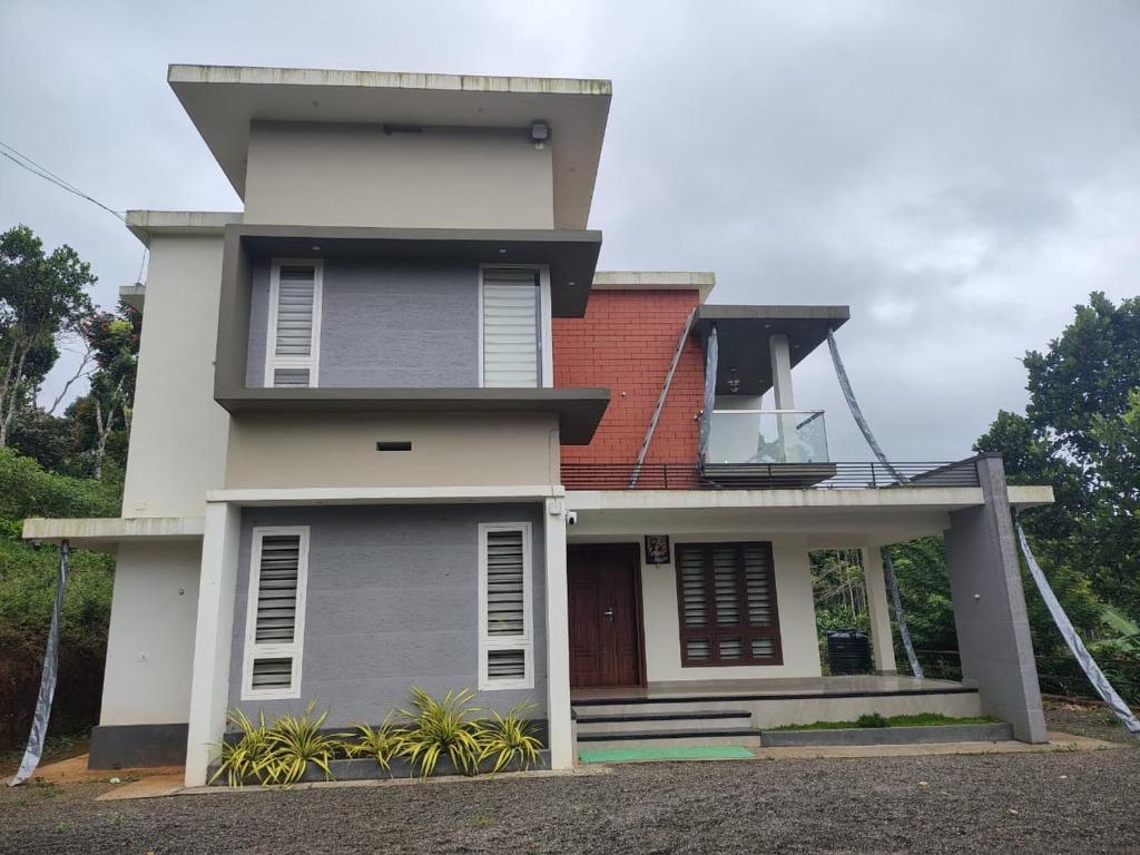 ein weißes Haus mit einem roten Dach in der Unterkunft Savisos home in Padinjarathara