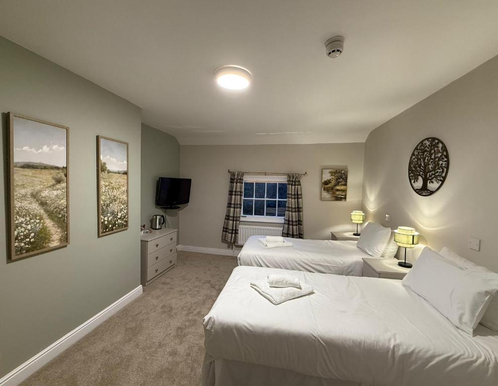 Una habitación de hotel con dos camas y un televisor. en The Mary Arden Inn, en Stratford-upon-Avon