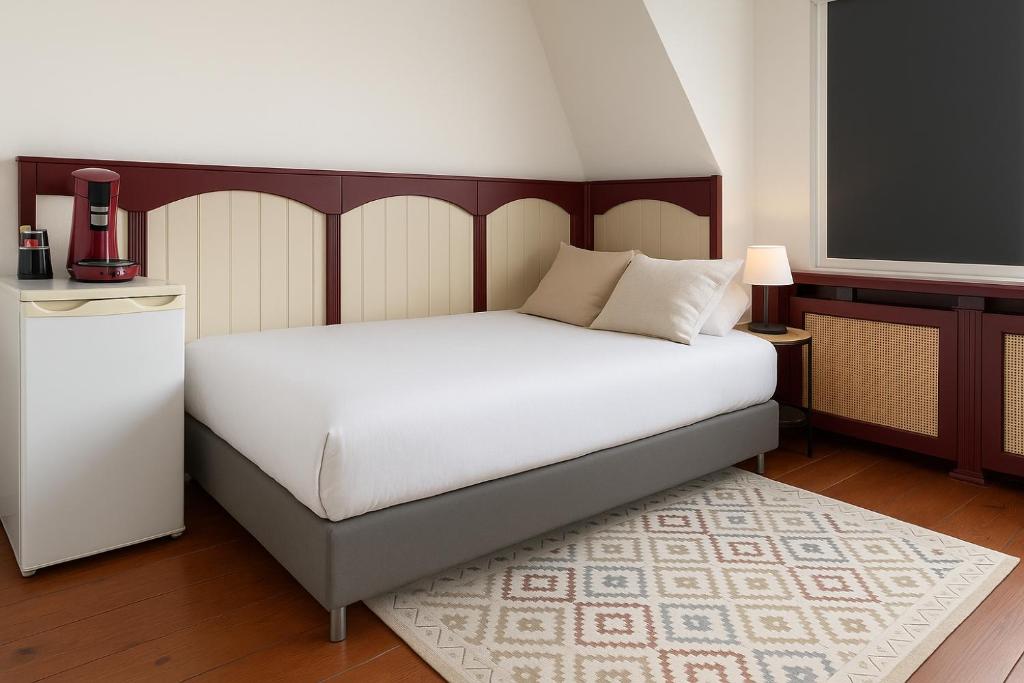 a bedroom with a large white bed with a white mattress at Sfeervolle kamer aan de Dorpsdijk met Gratis Ontbijt in Lobith