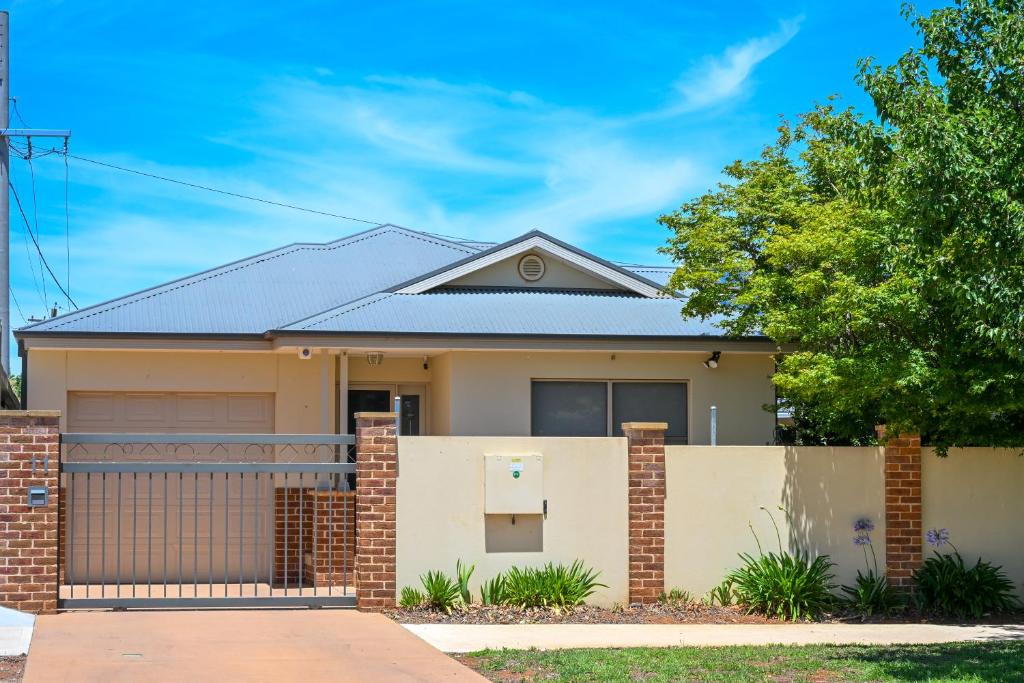 a house with a brick fence in front of it at Griffith Prestige Apartment in Griffith