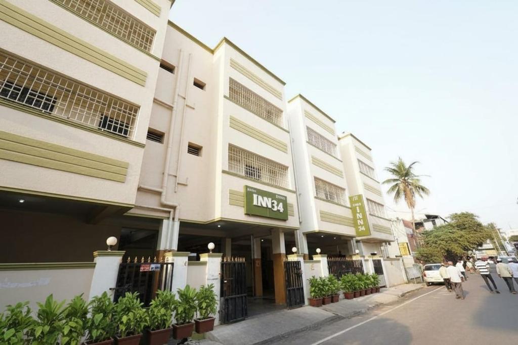 a building on a street with people walking in front of it at Inn34 By Blessings Hospitality - Porur Near DLF in Chennai