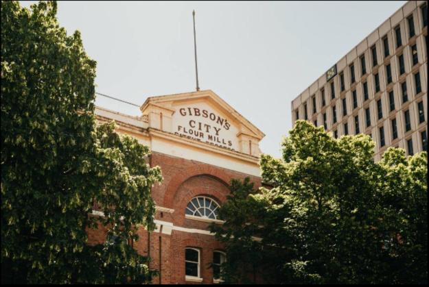 a sign on the side of a brick building at Gibson Mill waterfront warehouse apartment - 101 in Hobart
