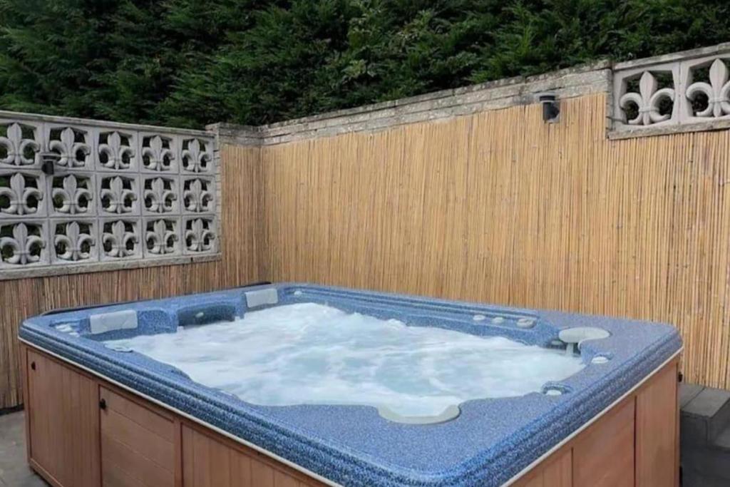 RentMySpaHome with Swimming Pool Hottub and Sauna في شيفيلد: يوجد حوض جاكوزي في الفناء الخلفي مع سياج