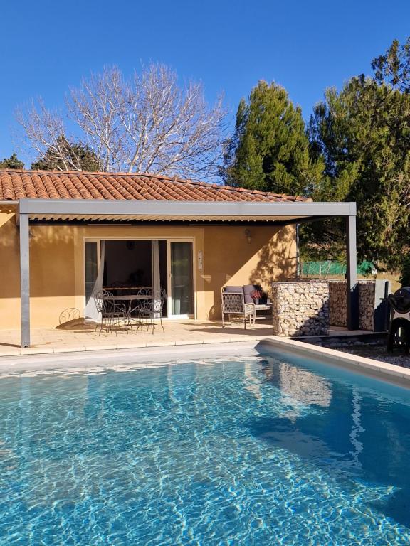 a swimming pool in front of a house at Au bout du chemin Chez Tina in Sarrians