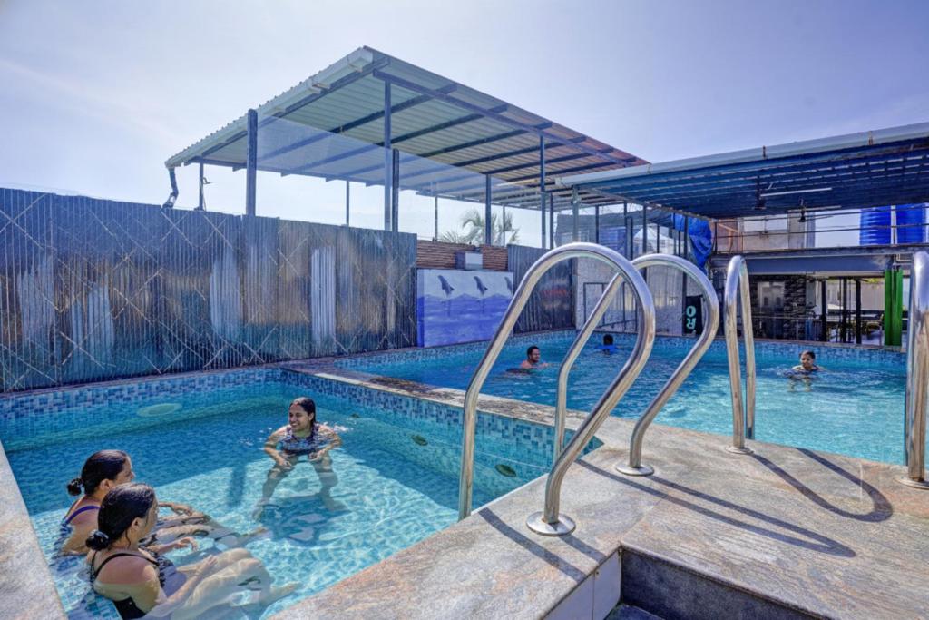 a group of people in a swimming pool at Hotel Small Daddy Plus in Calangute