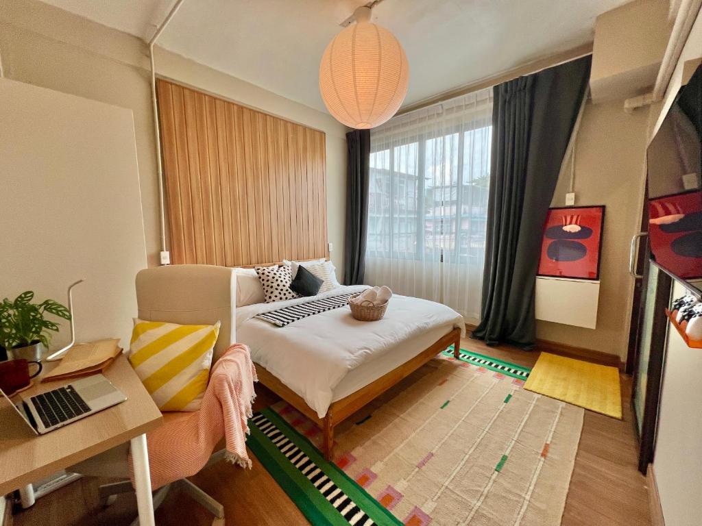 een woonkamer met een bank, een bureau en een laptop bij Office 3 in Bangkok