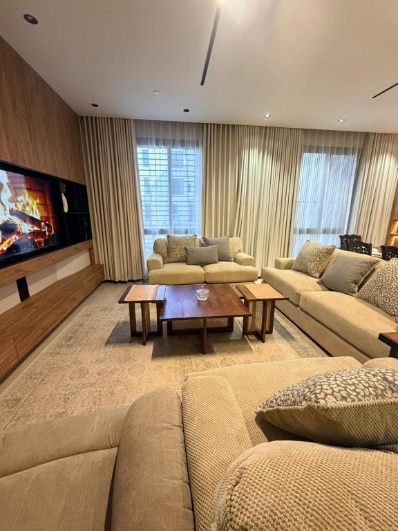 a large living room with couches and a tv at Excellence Apartment شقه التميز في المونسيه in Riyadh