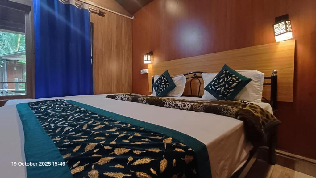Sai Palolem Beach cottages في بالوليم: غرفة نوم بسرير كبير وستارة زرقاء